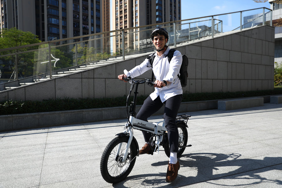 A smiling man enjoys an urban commute on his electric bike.