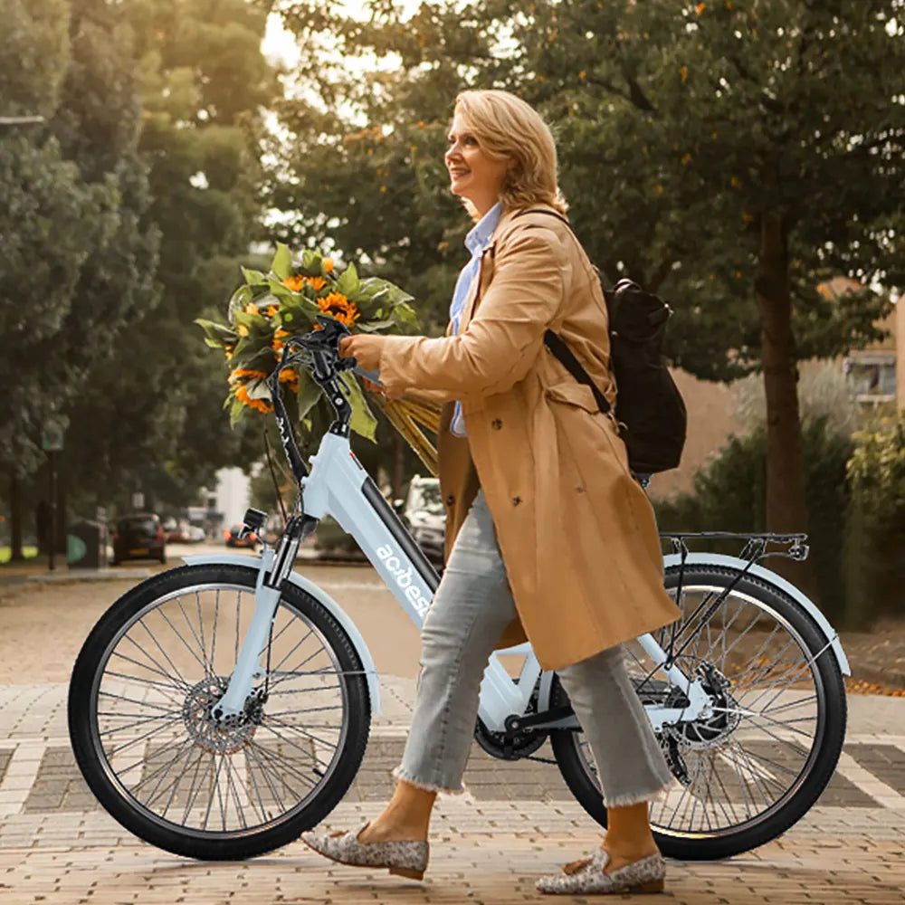 Woman walking with a light blue step-thru electric bike and bouquet of flowers.