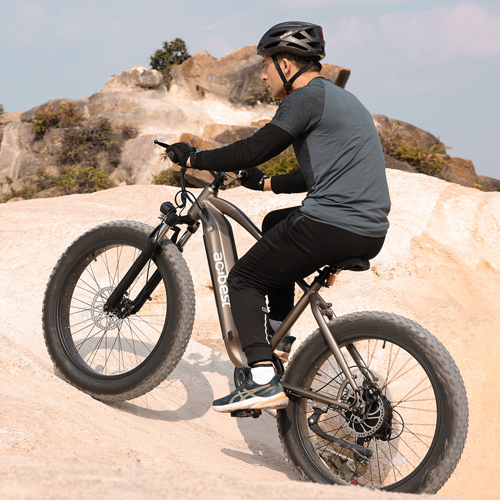 Rider on Actbest Ranger electric bike climbing rocky terrain.