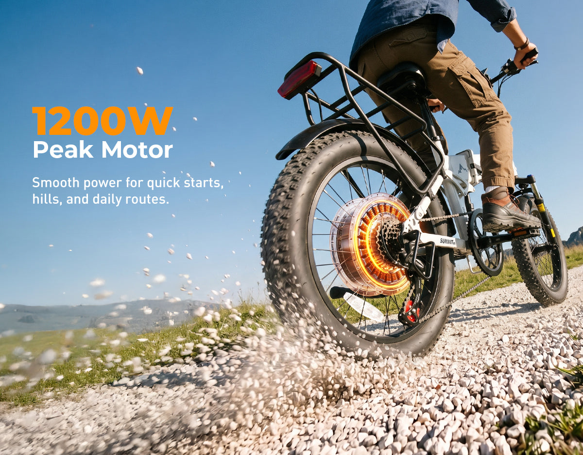 A person riding an electric fat-tire bicycle on a gravel path outdoors under a blue sky. The bike has a large rear tire, a rear rack, and a visible glowing orange rear wheel motor.