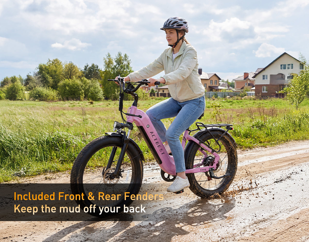 Actbest Cozy pink step-through electric bike with front and rear fenders riding through muddy roads to help keep the rider clean