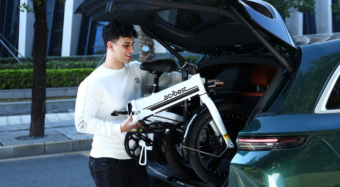 A man is loading a foldable motorcycle into the trunk of a car.