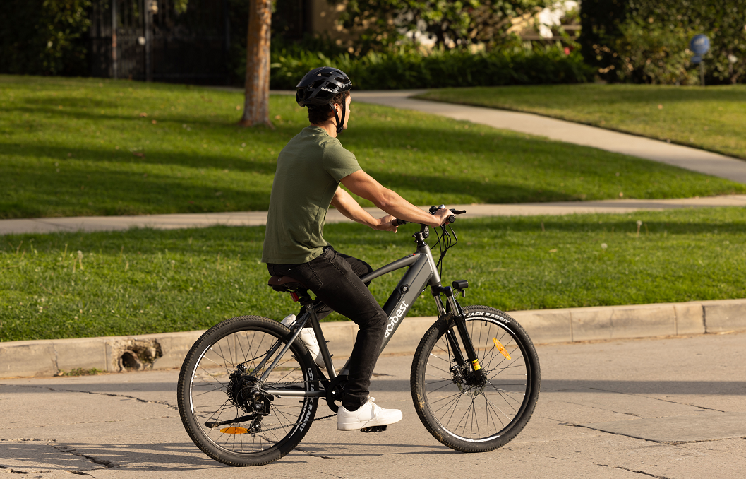 A man wearing a helmet riding an electric bicycle with a hub motor in the park