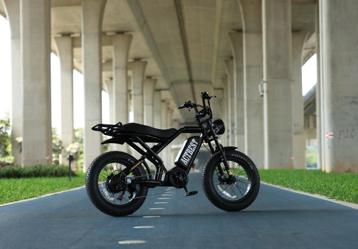 A cool actbest motorcycle with a fat tire sits under the overpass