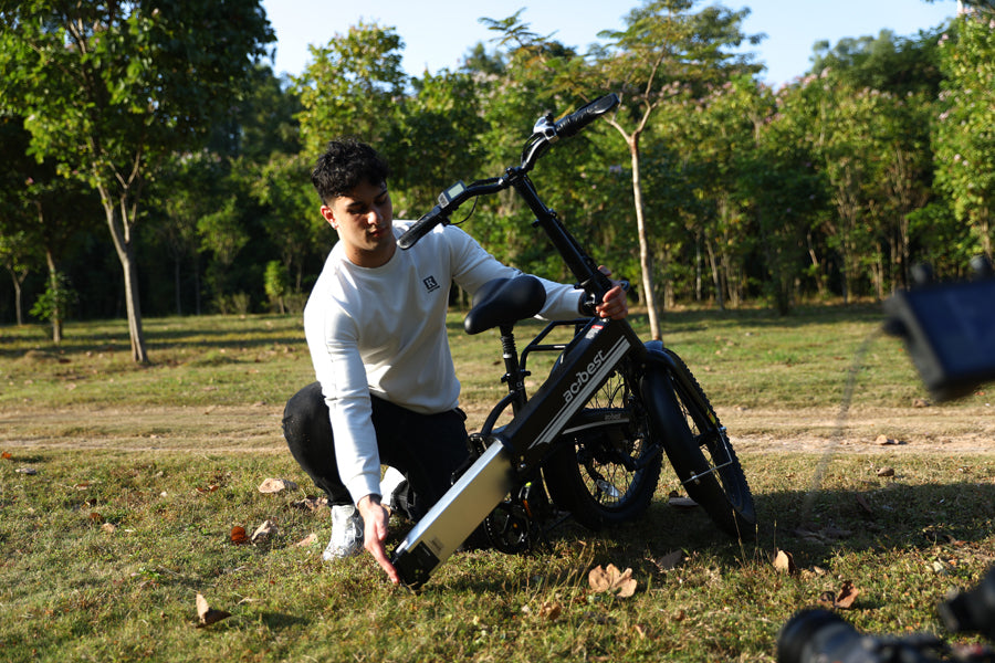 A man was changing the battery of his motorcycle in the grass