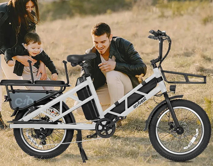 An adult and a child standing next to a white cargo e-bike.
