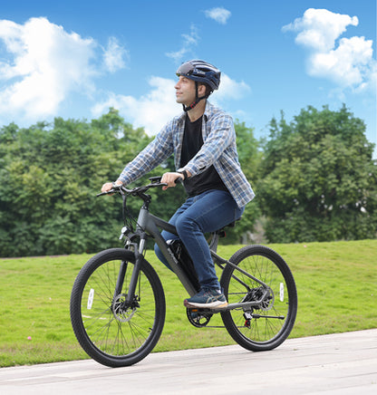 Man riding gray Actbest Race Electric Mountain Bike on smooth path outdoors.