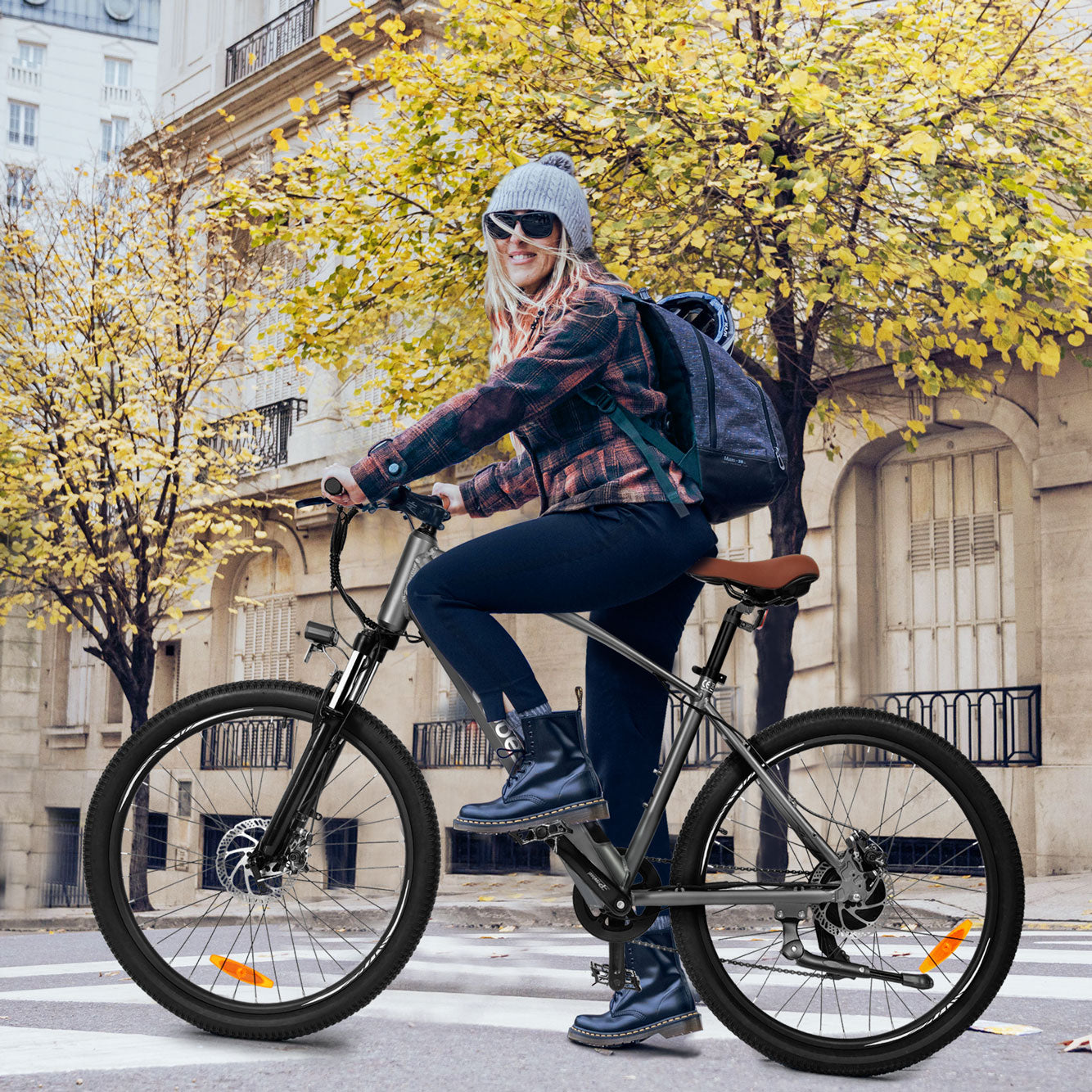 Woman riding Core Mountain Electric Bike on a city street with yellow autumn leaves.