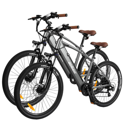 Sleek gray Core Mountain Electric Bikes with brown seats and all-terrain tires.