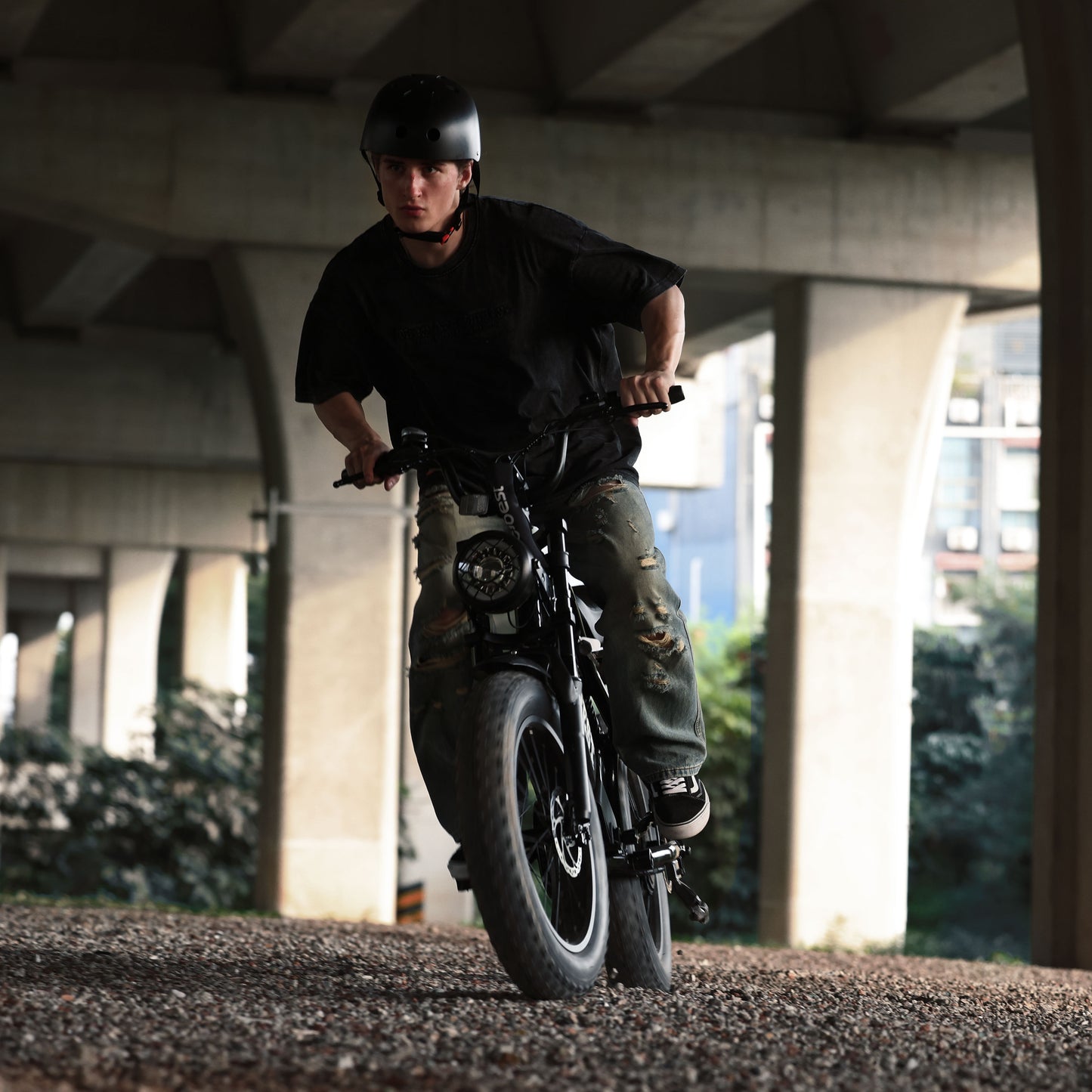 Rider on ACTBEST electric bike with fat tires, navigating urban terrain.