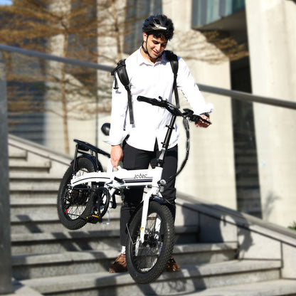Man carrying a foldable electric bike with fat tires down stairs.