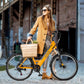 Woman in stylish outfit with yellow Actbest Core Step-Through Electric Bike and basket.