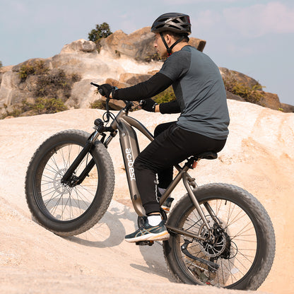 Rider on Actbest Ranger electric bike climbing rocky terrain.
