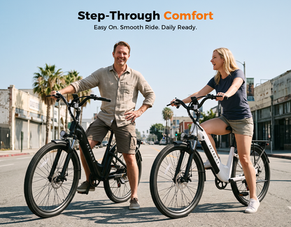 A man and a woman stand on electric bicycles on a sunny city street, with the text 'Step-Through Comfort' at the top. The man wears a beige shirt and shorts, and the woman wears a dark gray shirt and shorts.