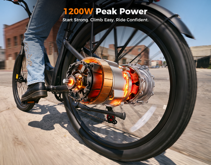 A close-up action shot of a person riding a bicycle outdoors, with the rear wheel and a large exposed electric motor assembly dominating the frame. The rider's lower leg in blue jeans and a black shoe is visible.