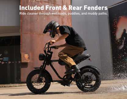 A person wearing a black helmet rides a black electric motorcycle outdoors, with large white text at the top reading 'Included Front & Rear Fenders' and smaller copy about riding cleaner through wet roads, puddles, and muddy paths.