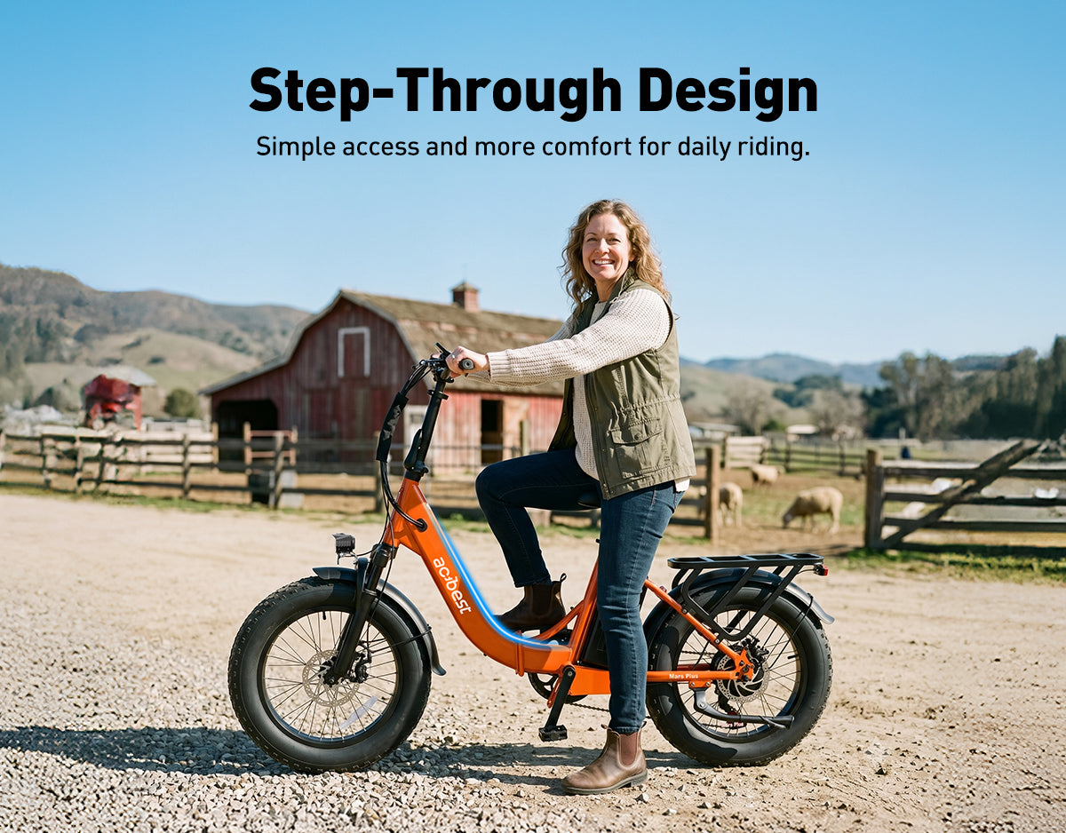 Woman showing the convenient step-through design of the orange Actbest Mars Plus ST e-bike in a farm setting, built for easy access and comfort