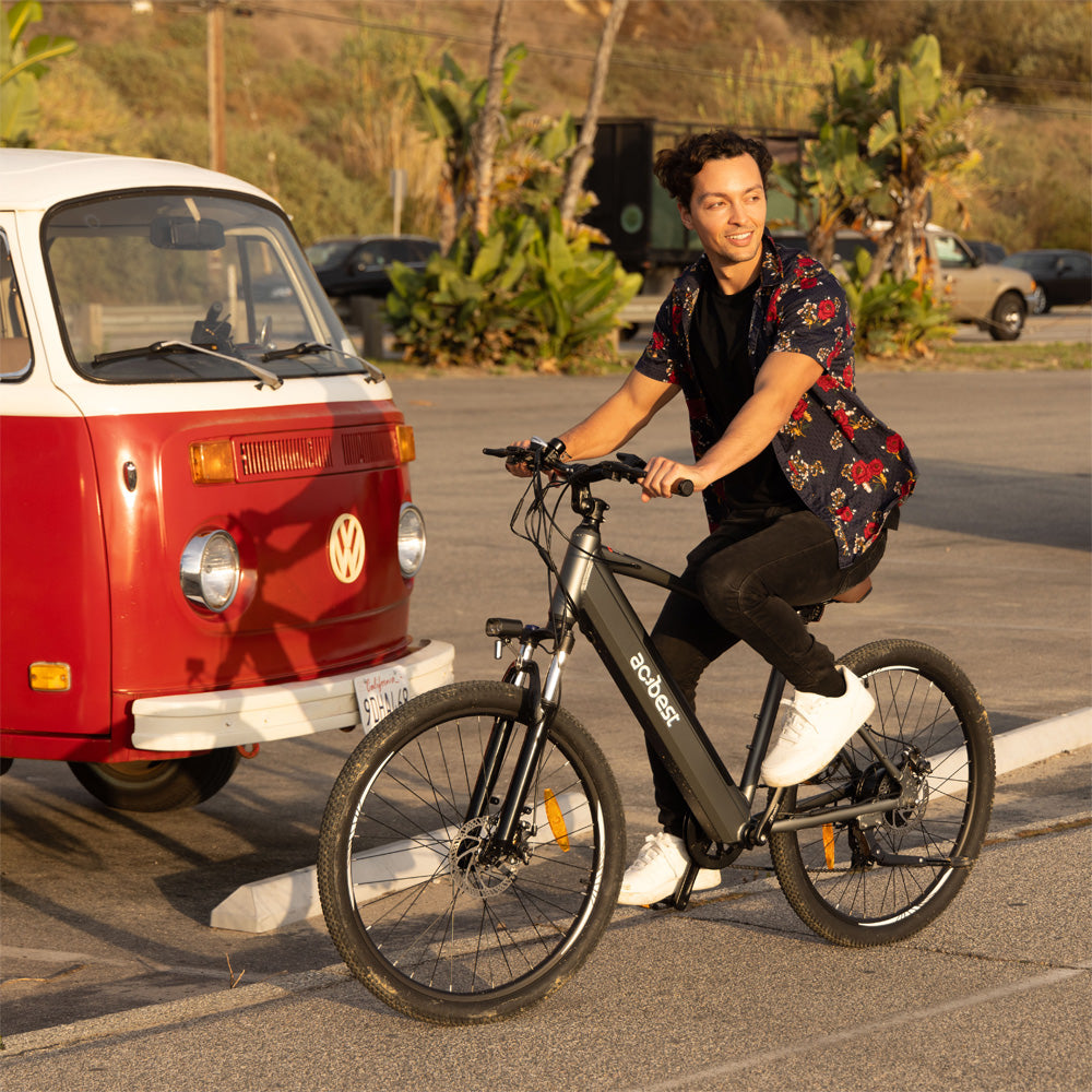 Man riding Core Mountain Electric Bike next to a vintage red VW van.